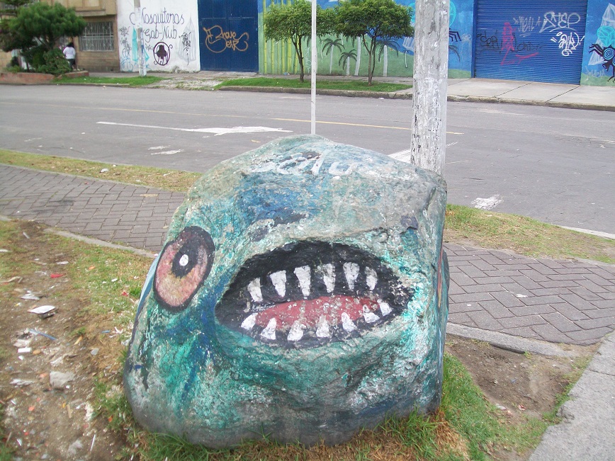 the other side of the rock is painted with a single eye and an open mouth with several long, sharp teeth